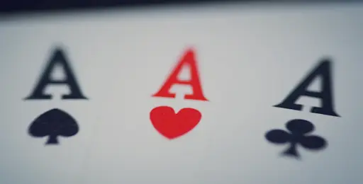 Forbes Casino — Hrací Karty s Esy pro Poker a Blackjack Detailní záběr na tři esa hracích karet — pikové, srdcové a křížové eso na bílém pozadí.