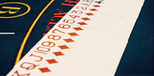 Forbes Casino — Hrací Stůl s Kartami a Karetními Hrami Detailní záběr na herní stůl Forbes Casino s rozloženými hracími kartami kárové barvy od esa po krále.